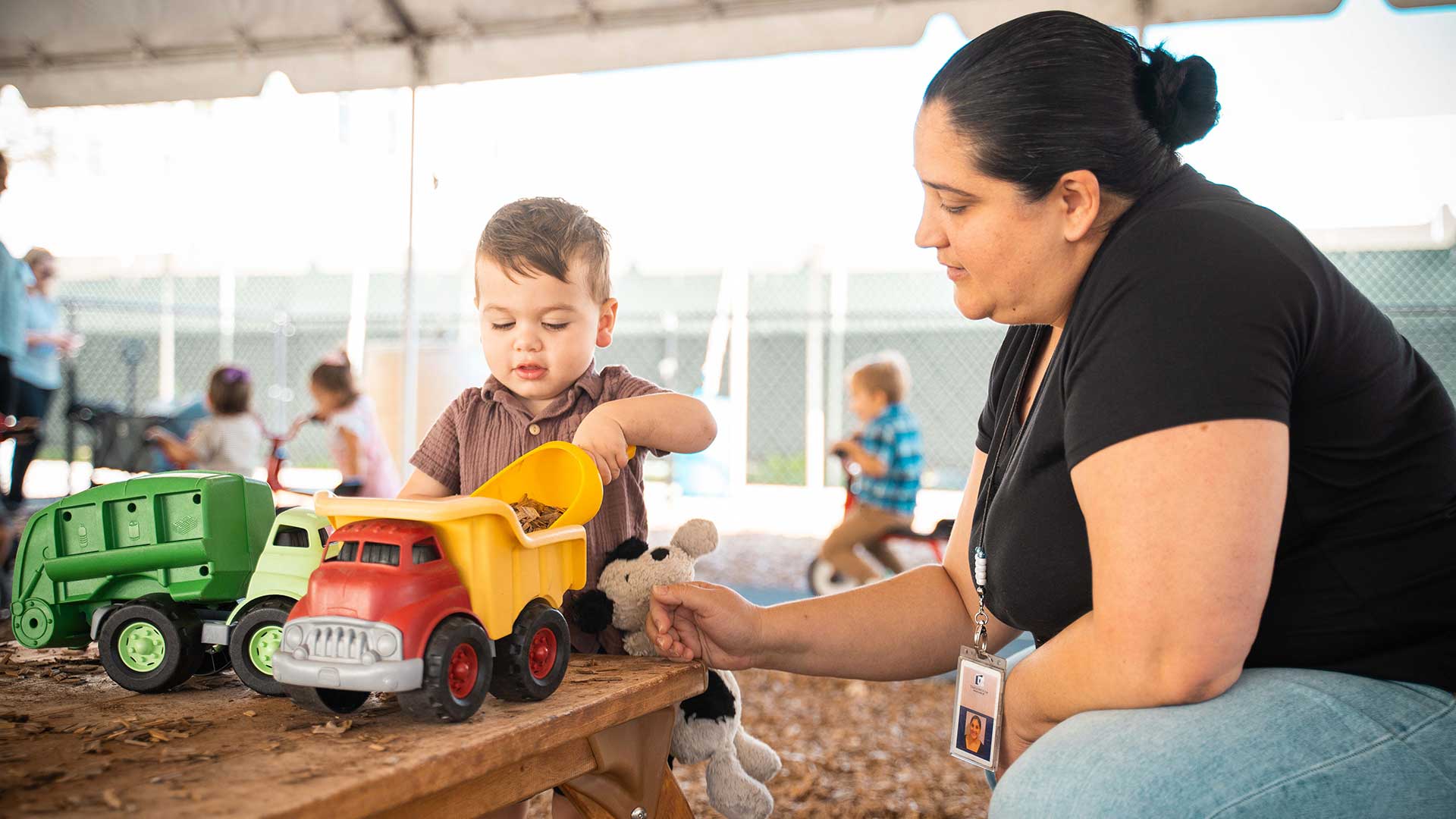 young boy playing with toy dump truck